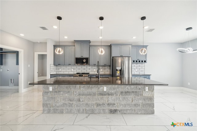 kitchen with decorative light fixtures, stainless steel appliances, and sink