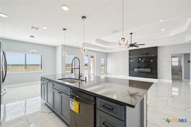 kitchen featuring a kitchen island with sink, hanging light fixtures, sink, ceiling fan, and black dishwasher