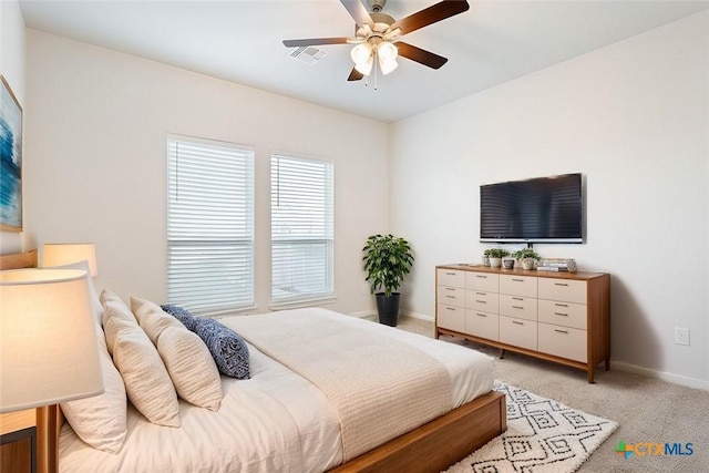 bedroom with ceiling fan and light carpet