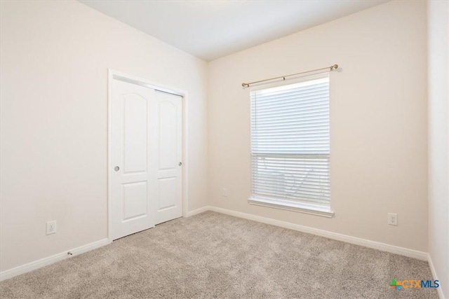 spare room featuring light colored carpet