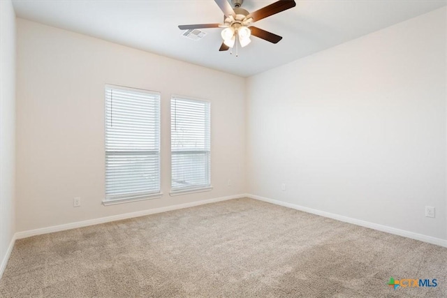 carpeted spare room with ceiling fan