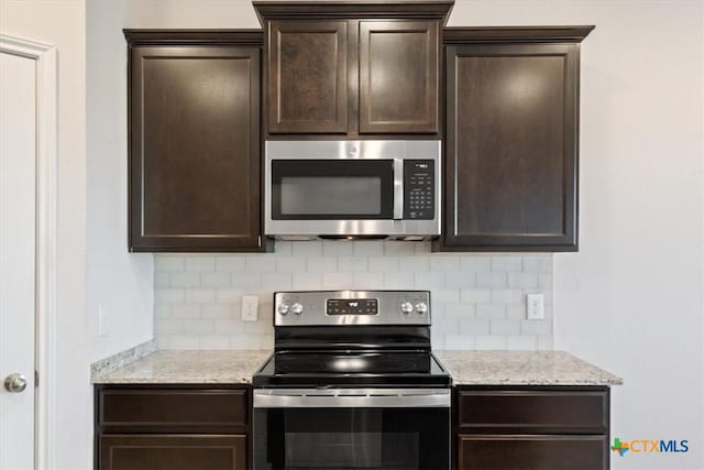 kitchen featuring tasteful backsplash, light stone countertops, and appliances with stainless steel finishes