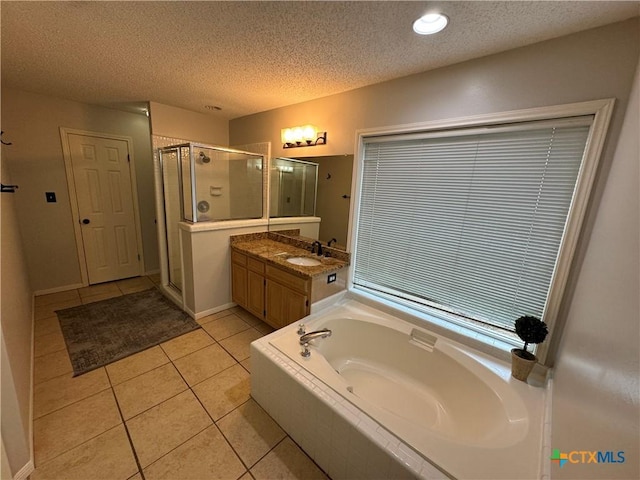 bathroom with tile patterned flooring, a shower stall, vanity, and a textured ceiling