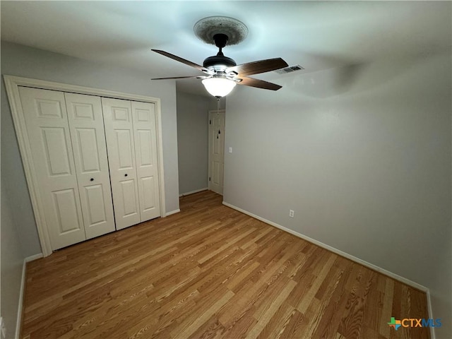 unfurnished bedroom with visible vents, baseboards, a ceiling fan, light wood-style flooring, and a closet