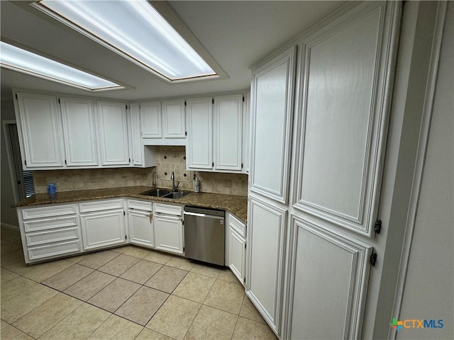 kitchen featuring a sink, light tile patterned floors, white cabinetry, and stainless steel dishwasher