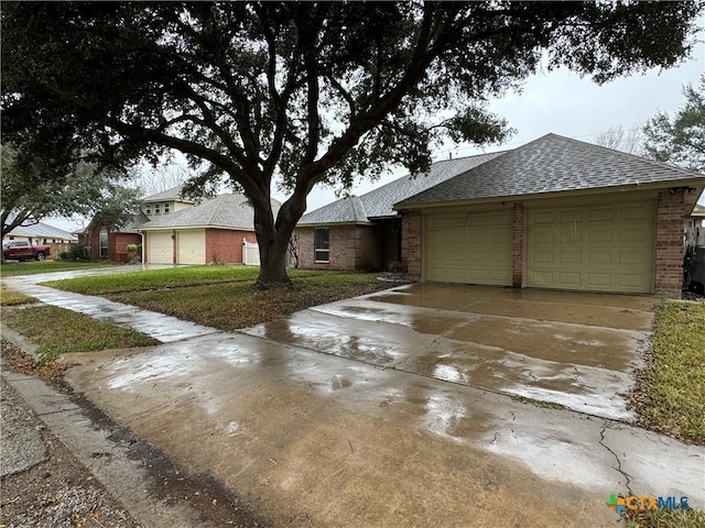 single story home featuring a garage, roof with shingles, concrete driveway, and brick siding