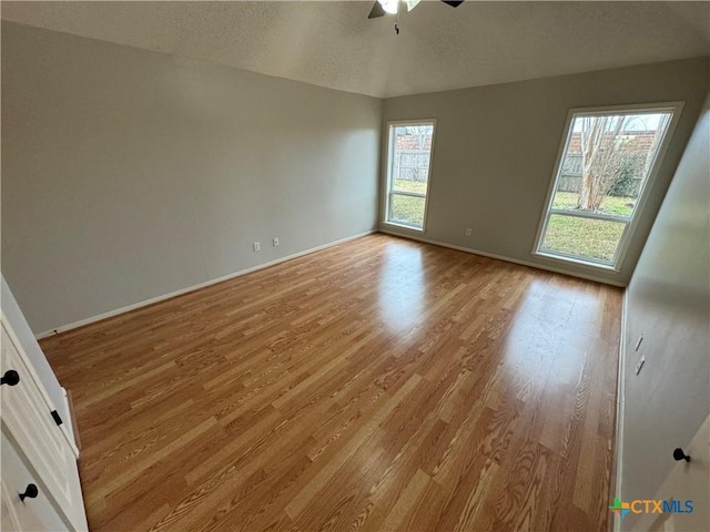 unfurnished room with a wealth of natural light, light wood-style flooring, and baseboards