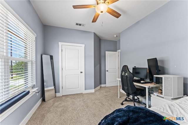 carpeted office space featuring a ceiling fan, baseboards, and visible vents