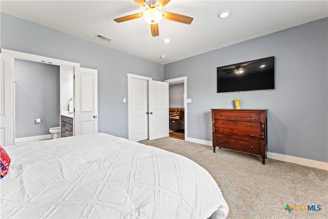 bedroom with visible vents, ensuite bath, carpet flooring, baseboards, and ceiling fan