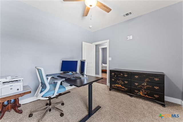 carpeted home office featuring visible vents, baseboards, and a ceiling fan