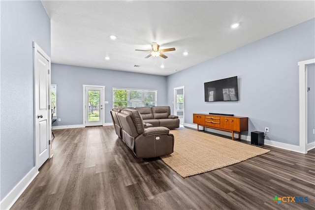 living room featuring dark wood-style floors, baseboards, and a ceiling fan