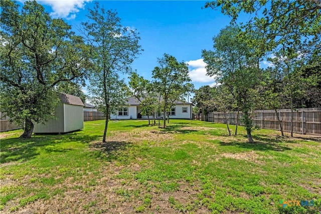 view of yard featuring an outbuilding, a fenced backyard, and a shed