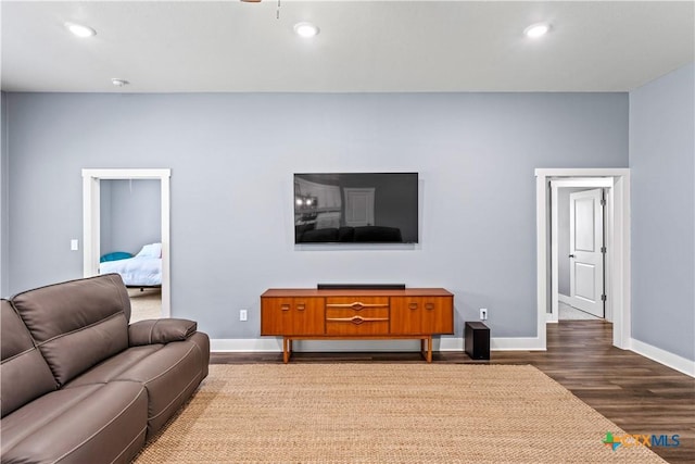 living area with dark wood-type flooring, recessed lighting, and baseboards