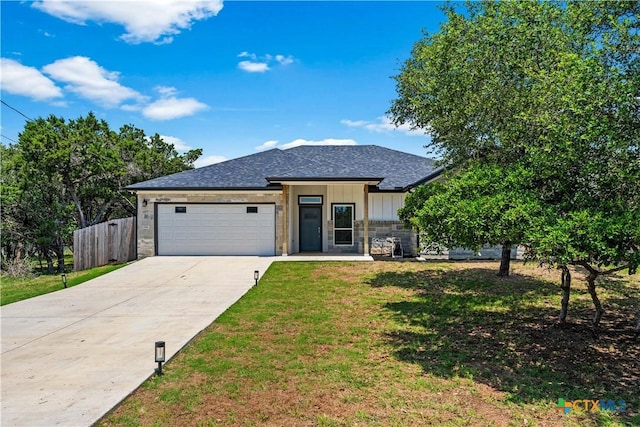 view of front of home featuring a front lawn, fence, board and batten siding, concrete driveway, and an attached garage