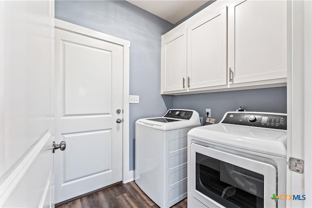 washroom featuring dark wood-style floors, cabinet space, and washer and clothes dryer