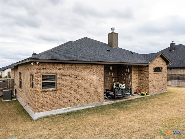 rear view of house with a lawn, a patio area, and central AC unit