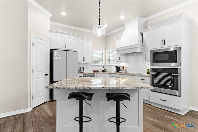 kitchen featuring dark hardwood / wood-style flooring, custom range hood, black appliances, a center island, and white cabinetry