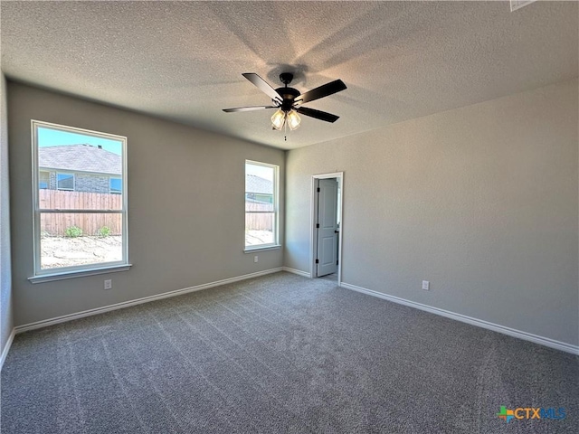 carpeted spare room featuring a ceiling fan, baseboards, and a textured ceiling