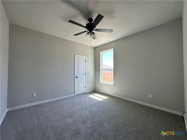 unfurnished room with carpet flooring, baseboards, and a ceiling fan