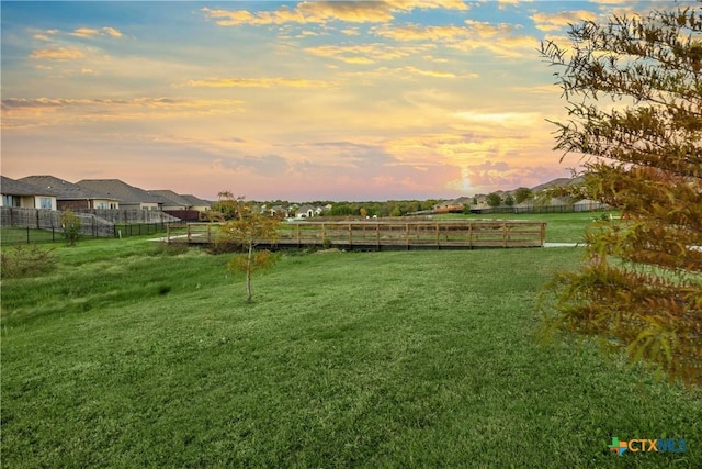 yard at dusk featuring a rural view