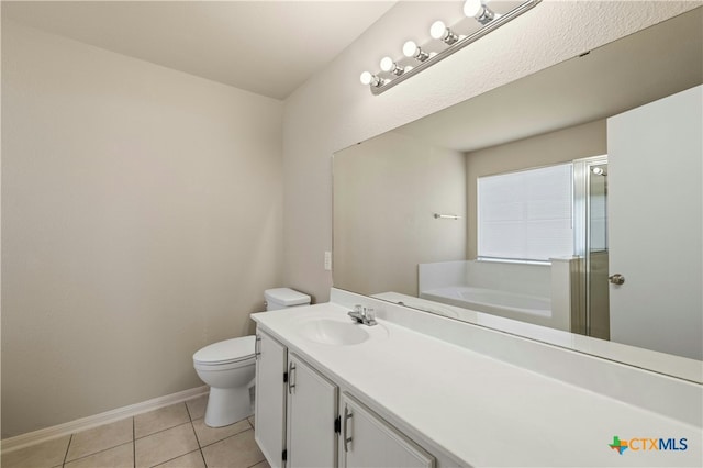 bathroom with tile patterned flooring, vanity, toilet, and a tub