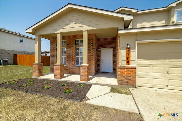 view of front of home with central AC unit, a garage, and a front yard