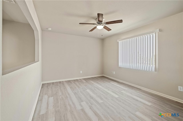 empty room with ceiling fan and light hardwood / wood-style flooring