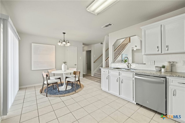 kitchen with white cabinets, dishwasher, light stone countertops, and sink