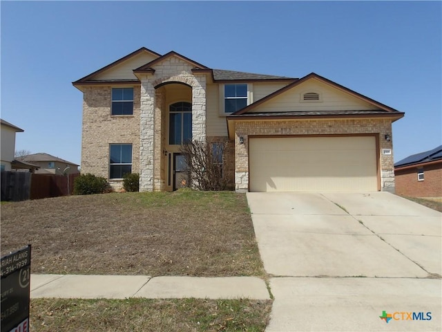 view of front of house with driveway, a garage, fence, and brick siding