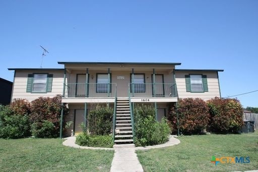 view of front of house with a front yard and a balcony