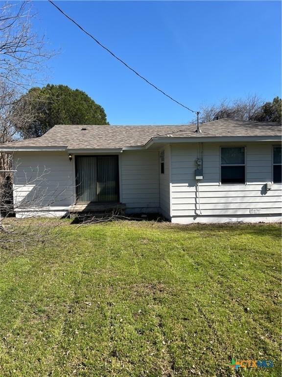 rear view of property featuring a lawn