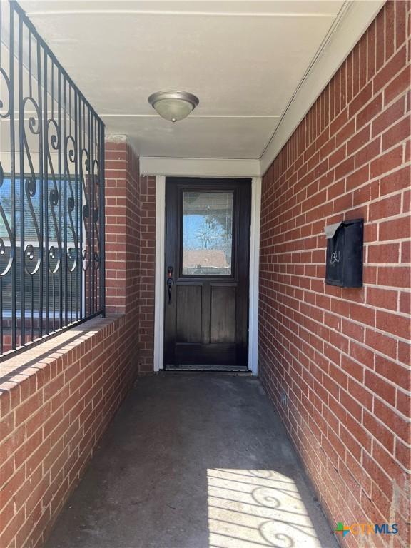 doorway to property featuring brick siding