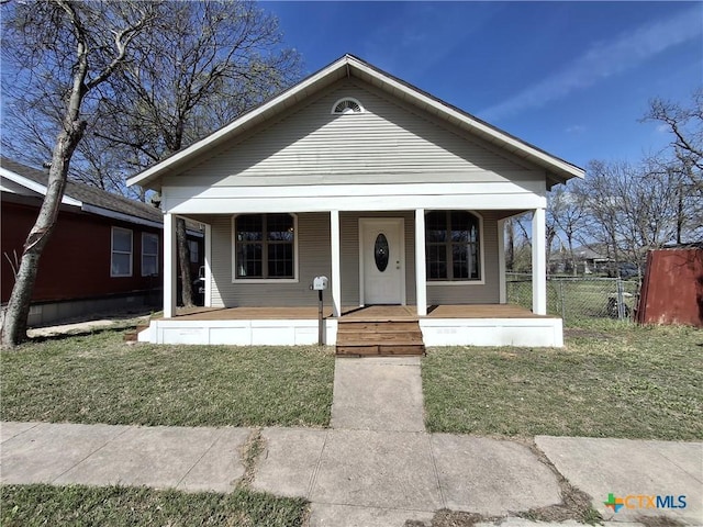 view of front of property featuring a front yard, a porch, and fence