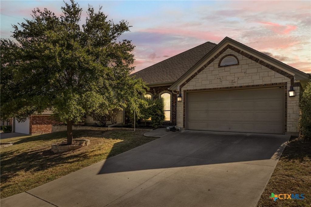 view of front of house featuring a garage and a yard