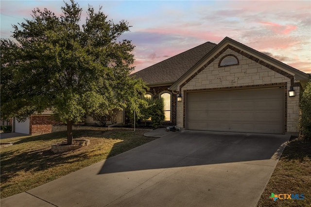 view of front of house featuring a garage and a yard