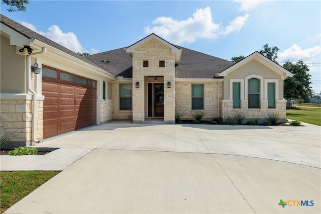 200 Wood Cv, Georgetown, TX 78633 - ranch-style house with an attached garage, concrete driveway, stone siding, and roof with shingles