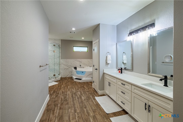 200 Wood Cv, Georgetown, TX 78633 - bathroom with a shower stall, wood finished floors, double vanity, a garden tub, and recessed lighting