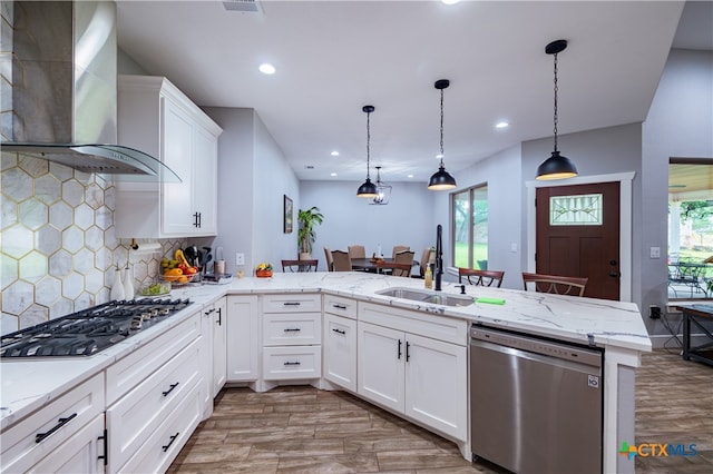 200 Wood Cv, Georgetown, TX 78633 - kitchen featuring stainless steel appliances, wall chimney exhaust hood, a sink, light wood-style floors, and recessed lighting