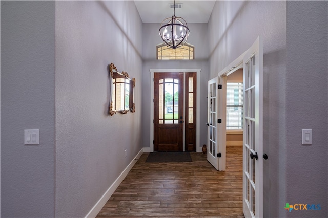 200 Wood Cv, Georgetown, TX 78633 - foyer entrance with french doors, dark wood-type flooring, a chandelier, a textured wall, and baseboards