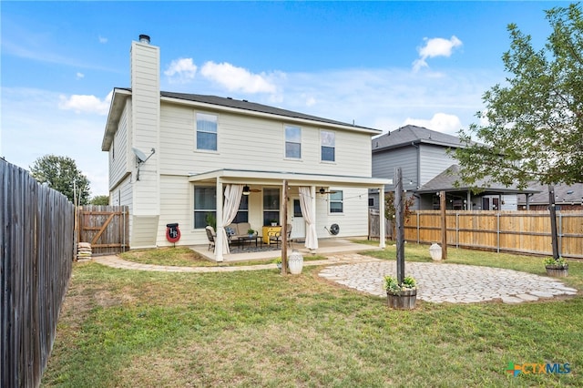 rear view of property with a lawn and a patio