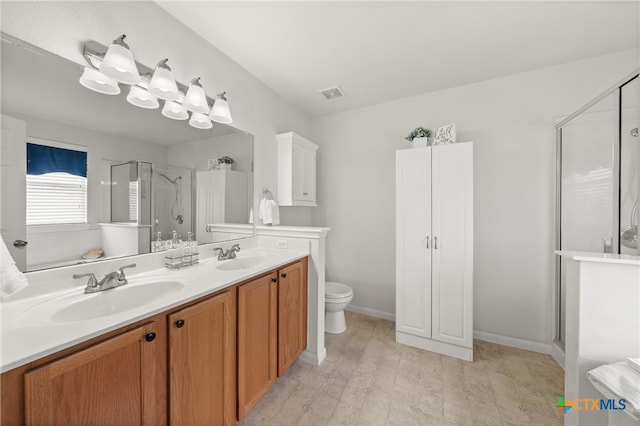 bathroom featuring vanity, toilet, and an enclosed shower