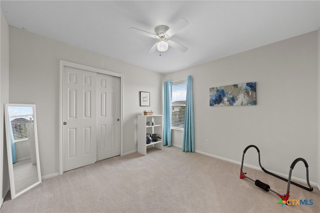 interior space featuring ceiling fan, light carpet, and a healthy amount of sunlight