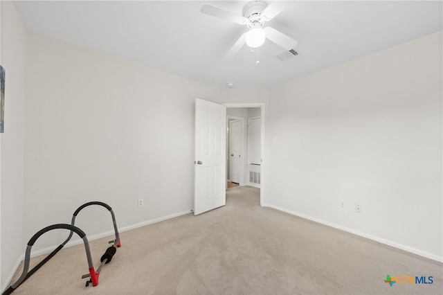 carpeted spare room featuring ceiling fan