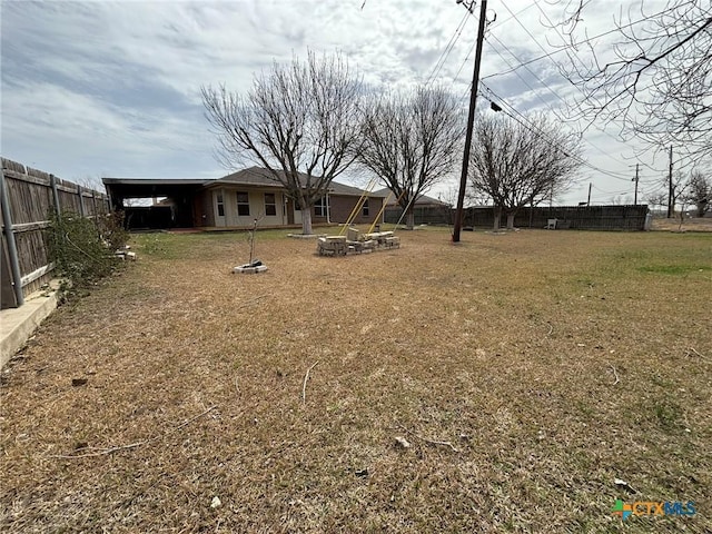 view of yard with an outdoor fire pit and fence