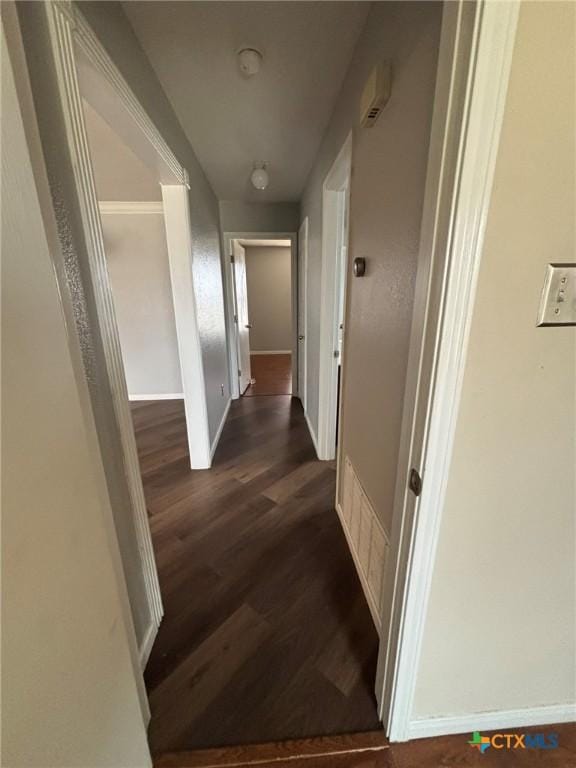 hall featuring dark wood-style floors and baseboards