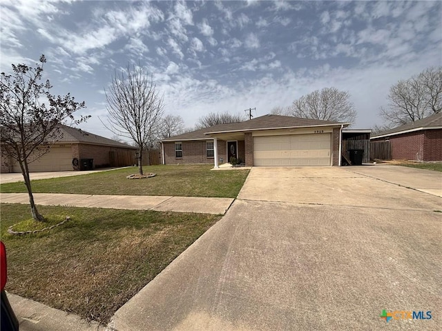 ranch-style home with a garage, brick siding, concrete driveway, and a front lawn