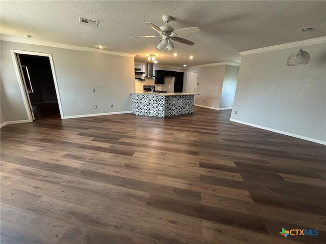 unfurnished living room with a textured ceiling, visible vents, dark wood-style flooring, and ornamental molding