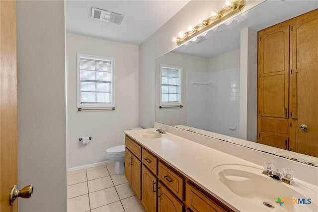 bathroom with toilet, vanity, and tile patterned floors