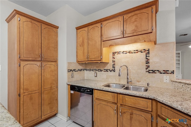 kitchen featuring sink, tasteful backsplash, light stone countertops, light tile patterned floors, and dishwasher