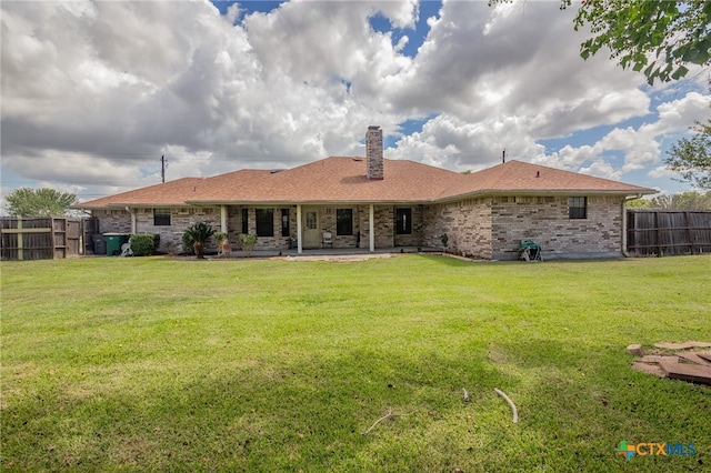 back of house with a patio area and a yard